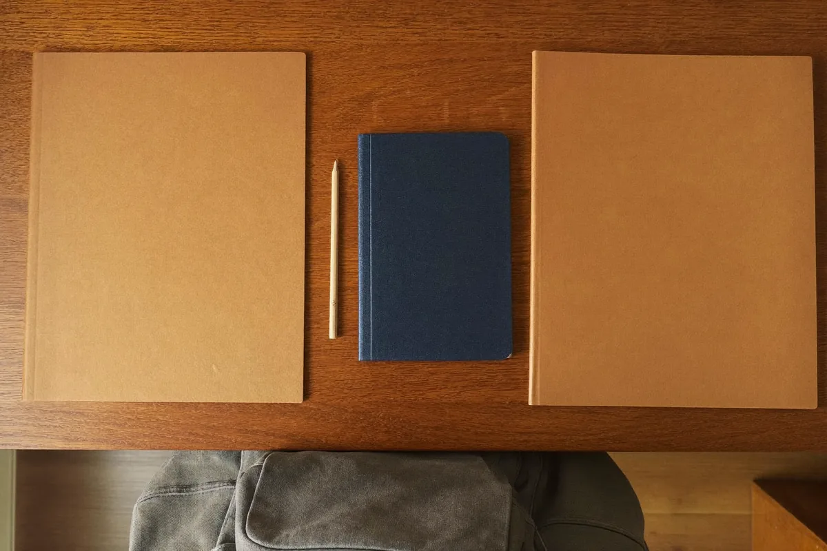 Dos carpetas cerradas y un cuaderno sin texto sobre un escritorio para organizar un plan de crianza